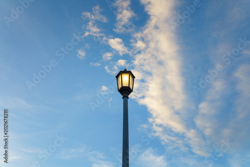 Tokyo, Japan - Oct 1 2024, Close-up view of a glowing street lamp against a blue sky with clouds, at evening, Tokyo, Japan