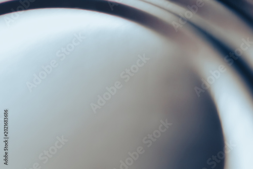 Silver metallic surface featuring a smooth texture with subtle circular grooves and shiny reflections. Industrial background