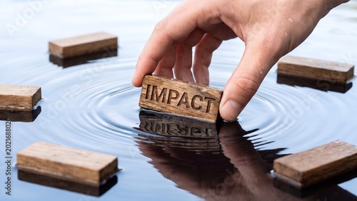 Hand dropping wooden block with impact into rippling water surface