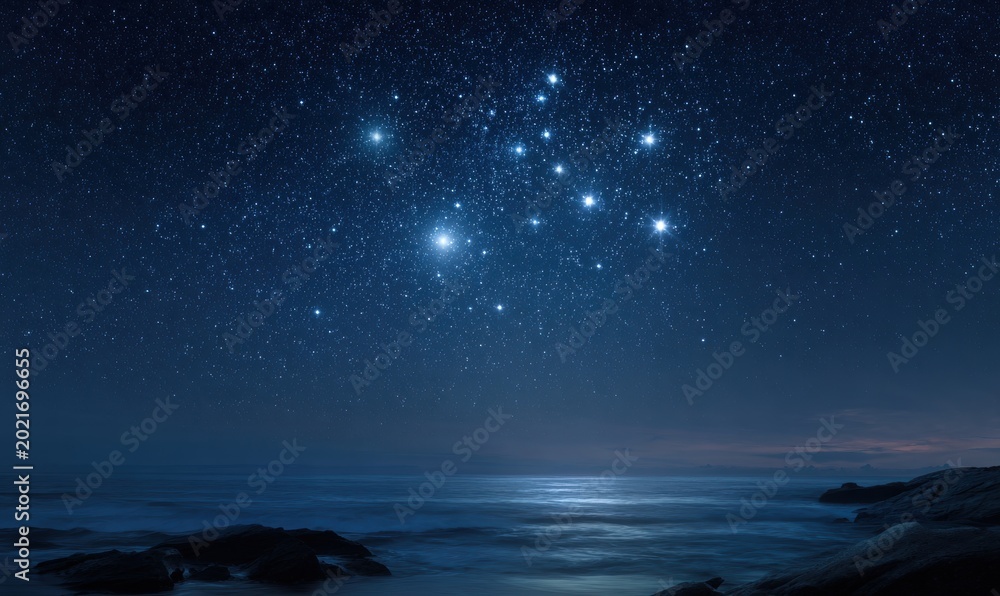 Fototapeta premium Starry night over sea, Ursa Minor visible, calm waters, rocky shoreline