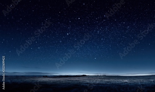 Night sky filled with stars over quiet, empty plains