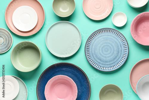 Fotografie Different plates with bowls on turquoise background