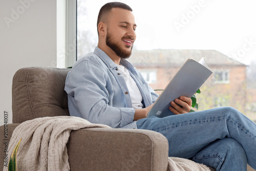 Young man reading magazine ...