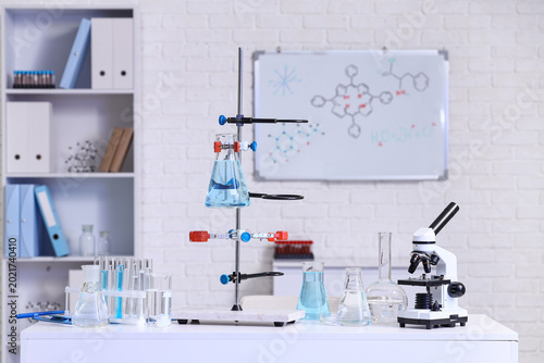 Stand with flasks of water samples and microscope on table in laboratory