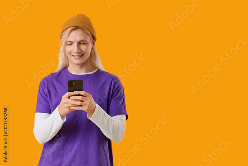 Young blonde man in hat usi...