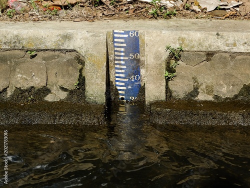 Fotografía hydraulic measurement tool features clear numerical markings to monitor canal water levels, essential for flood control and efficient irrigation management in farming areas