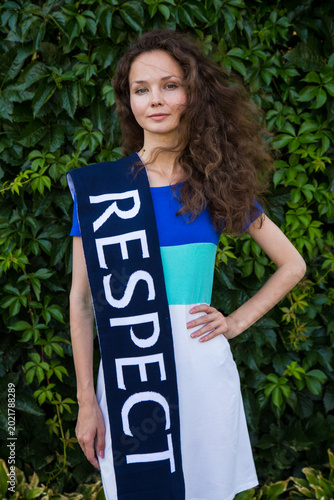 Fotografía Girl holding a scarf with a word Respect written on it