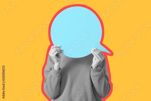 Woman hiding face behind bl...