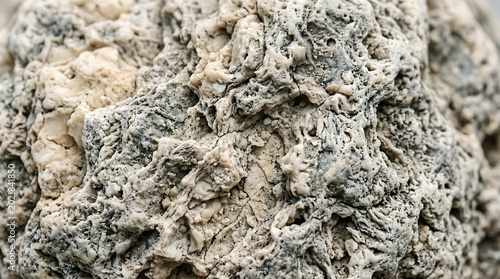 Raw ambergris extreme macro texture abstract ivory grey surface isolated on white background, luxury perfume material photography
