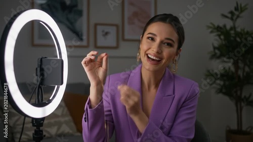 Video tutorial of woman applying makeup with ring light.