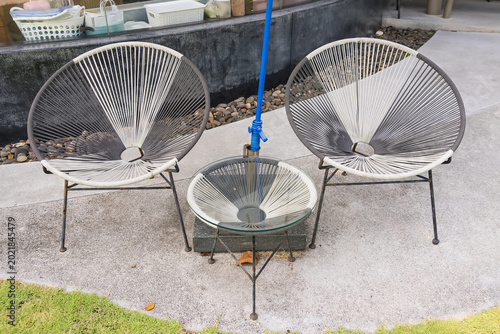 Relaxation Set: A sleek, modern outdoor seating set invites tranquility, featuring two minimalist chairs flanking a matching table, all perfectly arranged to enjoy a moment of peace.