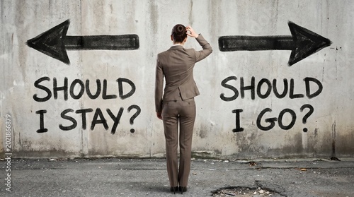 A business professional contemplates a critical life choice, facing two divergent paths indicated