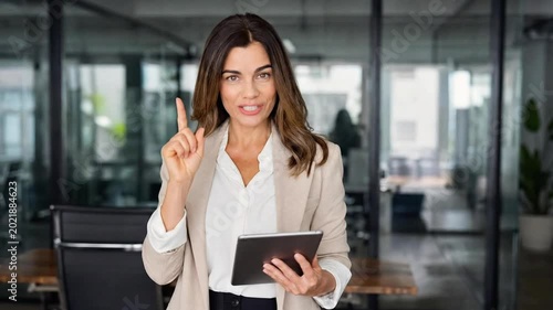 Confident Businesswoman Holding Digital Tablet and Pointing Finger Up Having Creative Idea in Modern Office