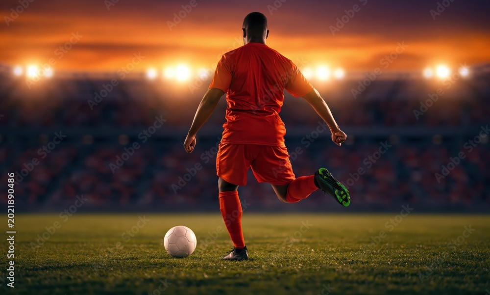 Naklejka premium Soccer player kicking ball in stadium during sunset