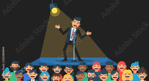 Comedian Performing On Stage To Laughing Audience Under Spotlight