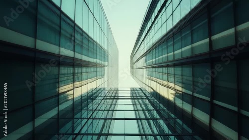 Modern glass facades of contemporary skyscrapers reflecting the environment upwards, forming a powerful, symmetrical architectural alley in a bustling business district