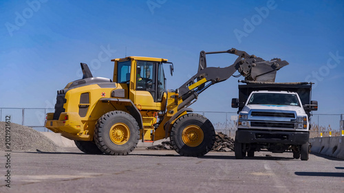 Tableau sur toile Sand loading process with front loader and dump truck