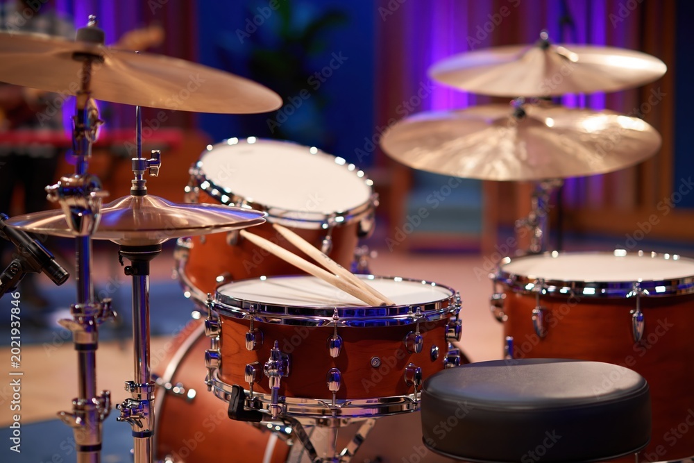 Obraz premium Acoustic drum kit with drumsticks, ready for performance in a studio setting
