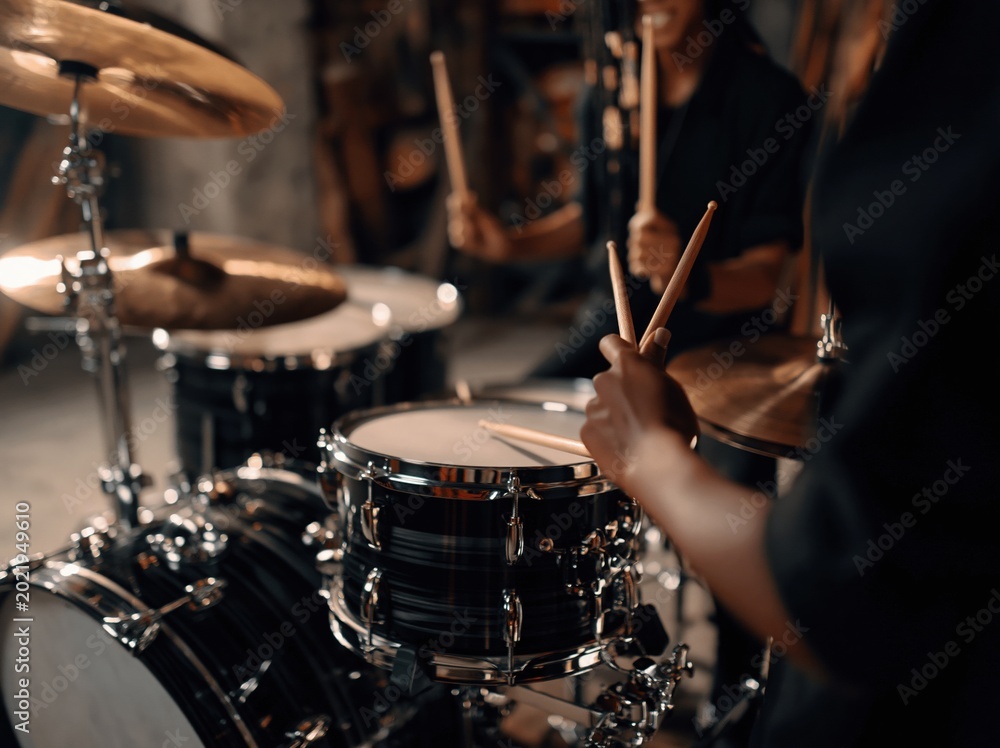 Obraz premium Close-up of hands playing a drum kit with drumsticks, emphasizing rhythm and performance