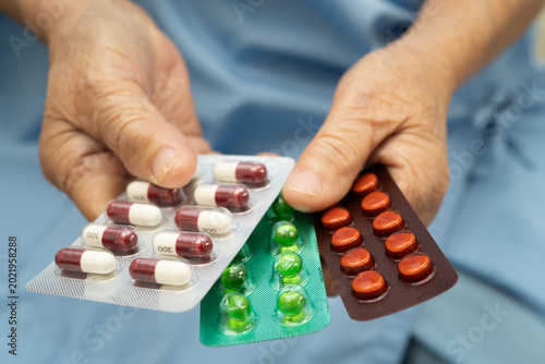Tableau sur toile Asian elderly woman holding pill drug in hand, strong healthy medical