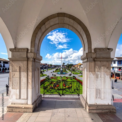 A scenic archway overlooking a park with green lawns and a blue sky
