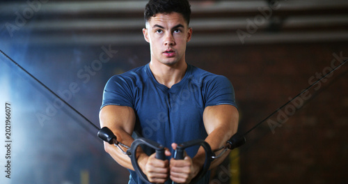 Foto Workout, man and cable weight machine in gym, fitness and resilience training for strength challenge