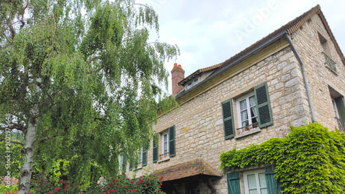 Картината върху платно Charming Traditional French Stone House with Green Shutters, Climbing Ivy, Weepi