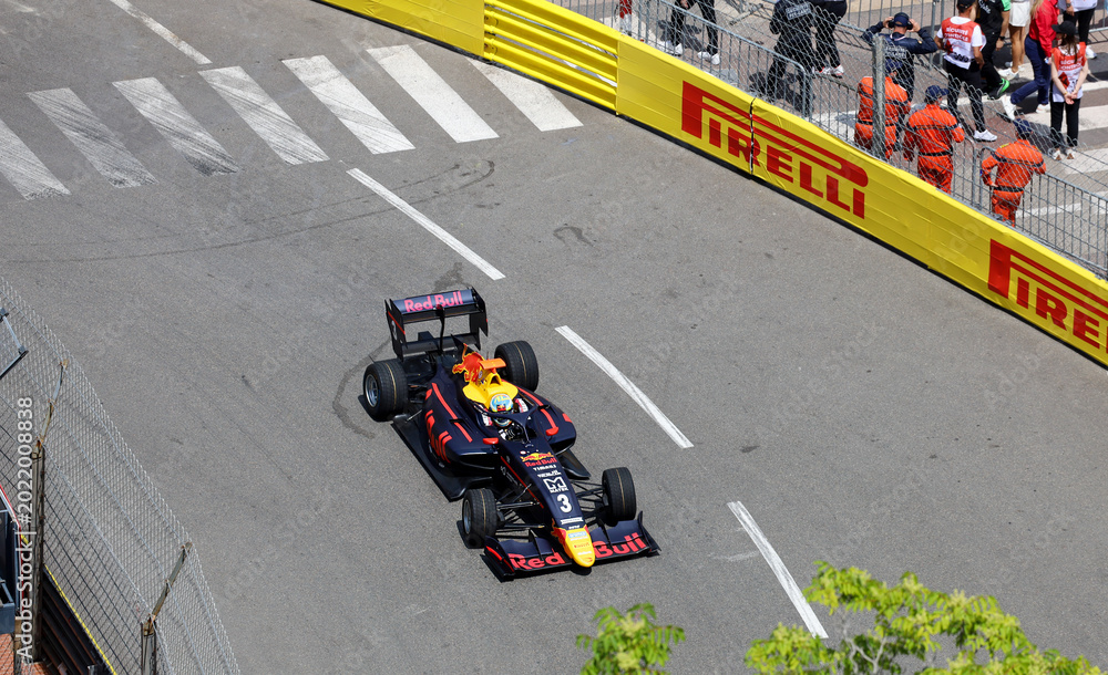 Naklejka premium Monaco-Ville, Monaco on May 24, 2024. Overhead editorial view of an open-wheel Formula 1 racing car in classic Red Bull livery navigating a sharp corner on the historic Monte Carlo street circuit.
