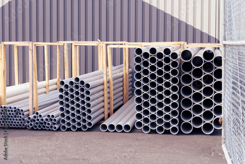 Foto Industrial PVC pipes stacked in wooden storage racks