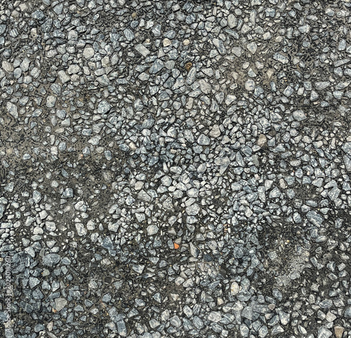 Grey crushed stone and gravel texture background, top view of rough aggregate surface.