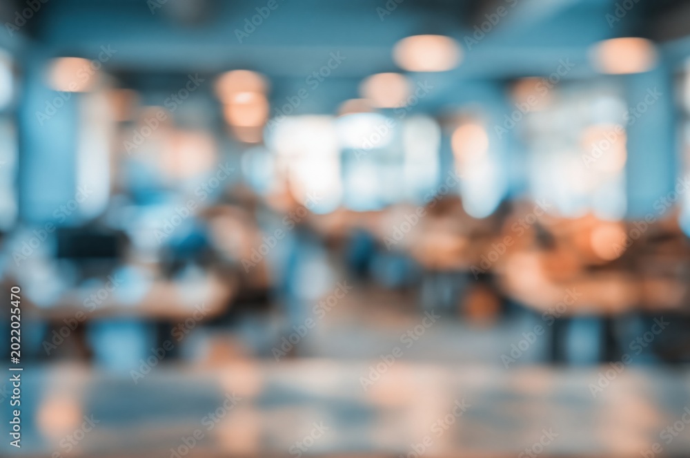 Fototapeta premium Blurred indoor scene of a modern cafe or restaurant with ambient lighting and patrons visible