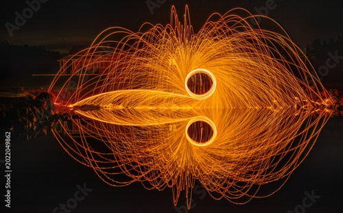Steel wool light painting reflected in the water.