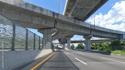 Empty highway road passing under concrete overpasses on a bright clear day