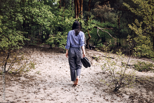 Принти на полотні Person stands barefoot in forest with arms outstretched looking upward