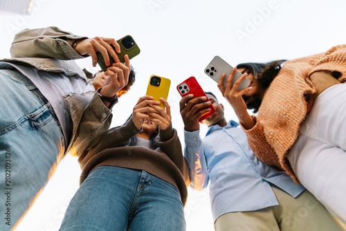 Photography Group of young friends interacting with their mobile phones, capturing content,
