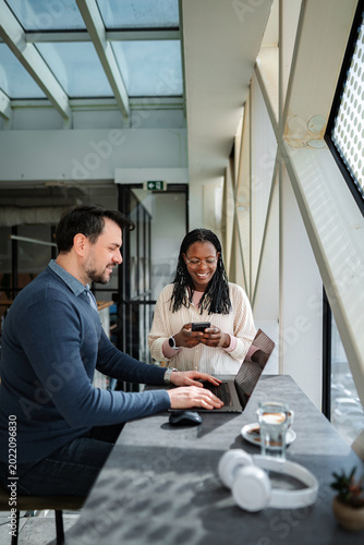 Diverse business professionals collaborating on work using technology