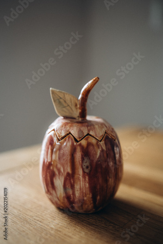 Schilderij op canvas Unique handmade ceramic trinket box in the shape of an elongated apple with a multi-colored glazed finish