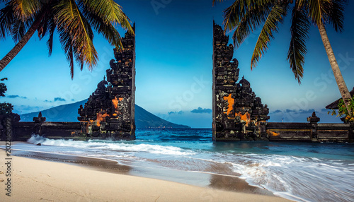 Ancient Balinese Temple Gate on a Tropical Beach with Ocean Waves Indonesia architecture