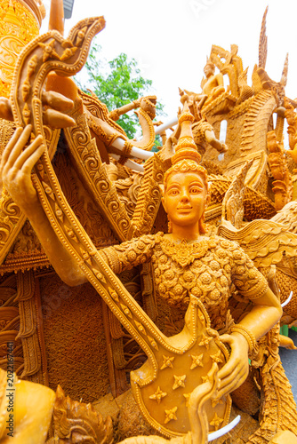 Tableau sur toile Beautiful yellow wax sculpture of a mythical female figure playing a traditional instrument during a Thai candle parade