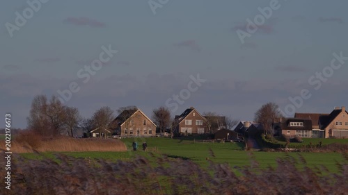People Walking on Scenic Path in De Donk Village at Sunset