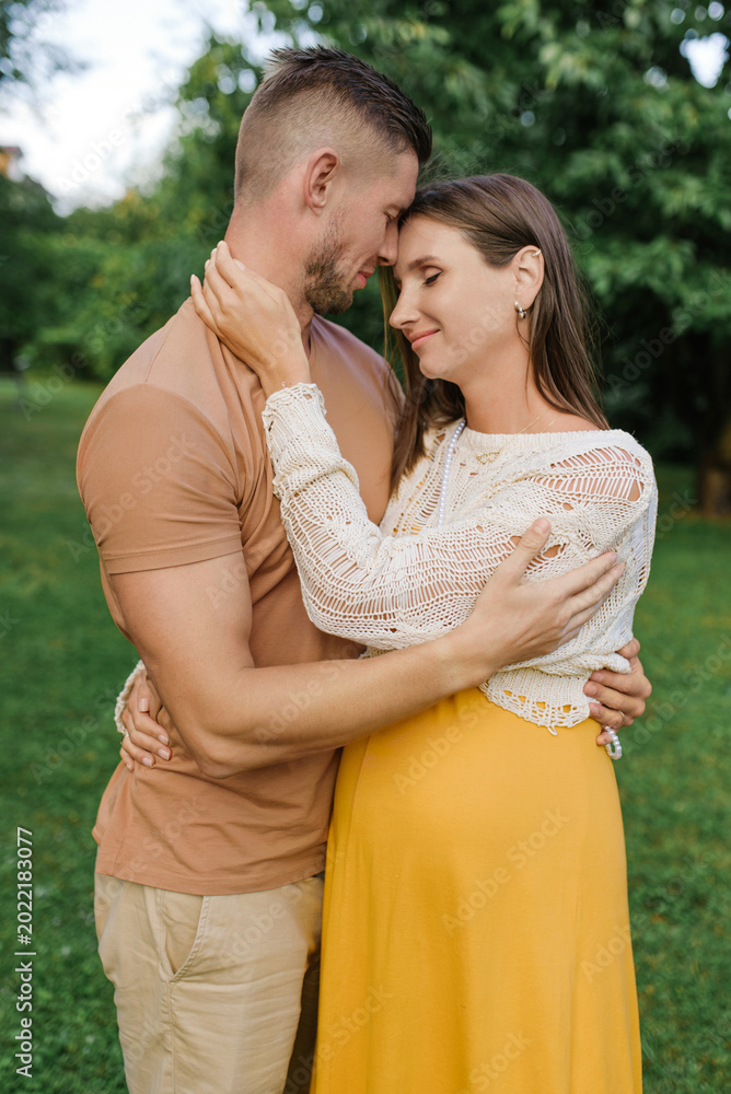 Fototapeta premium Tender Hug Of Expecting Couple In Garden