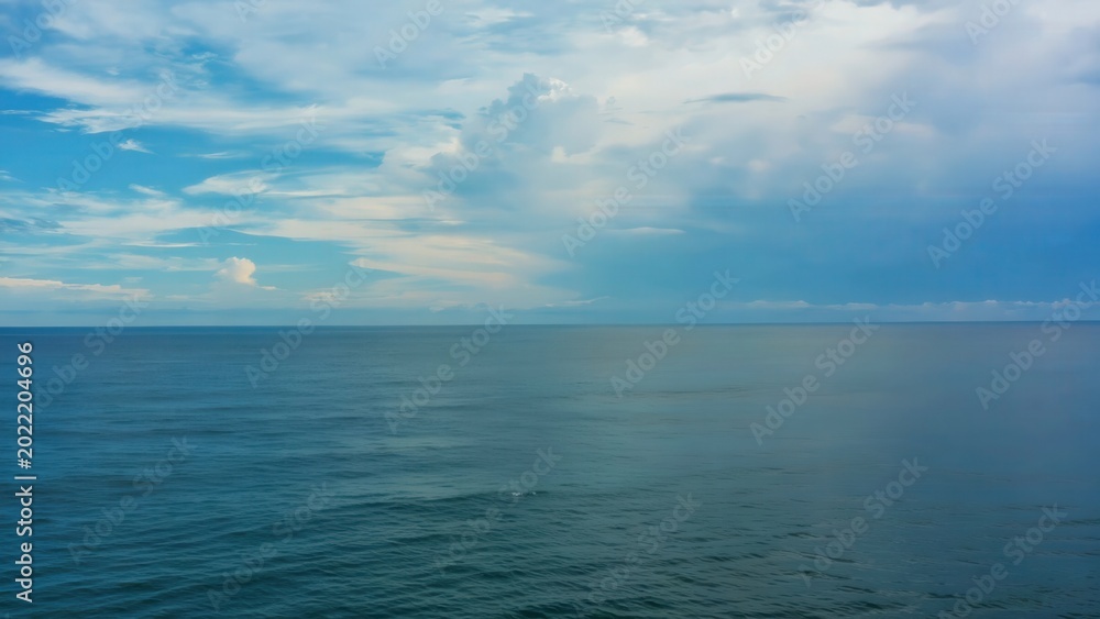 Fototapeta premium Vast open ocean under soft cloudy sky with deep focus, showcasing tranquil water surface and gentle waves, creating a serene coastal atmosphere in a wide shot