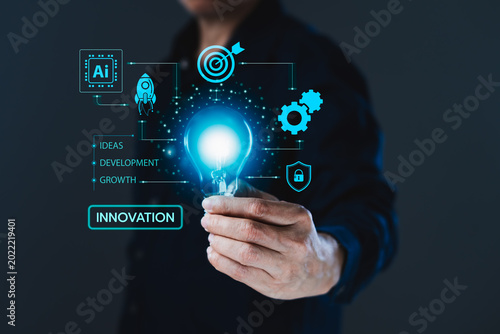 Businessman holding glowing light bulb with innovation, artificial intelligence and business growth interface