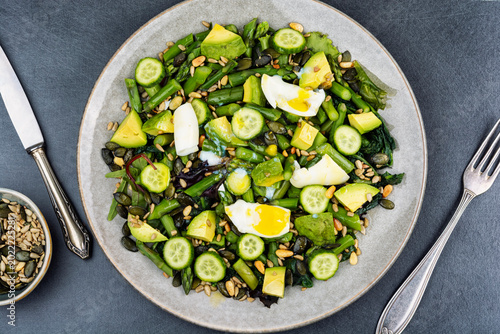 Fresh avocado and asparagus salad with seeds and egg