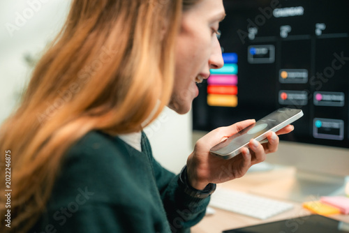 Φωτογραφία Modern woman using voice commands on her smartphone to interact with AI assistan