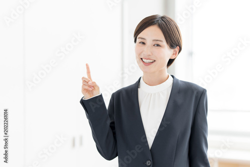 人差し指を立ててポイントを説明する笑顔のビジネスパーソン