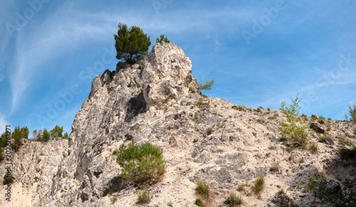 Bild auf Leinwand Skadar Lake ridge with limestone peak and pine trees under clear blue sky