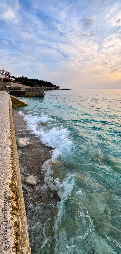 Fototapeta premium Adriatic coast Dobra Voda Montenegro with turquoise waves and pastel sky