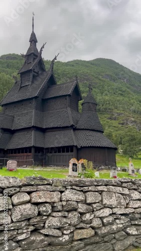 Borgund Stave Church in Norway, an outstanding example of medieval wooden architecture, surrounded by lush greenery and historic gravestones in a peaceful cultural landscape