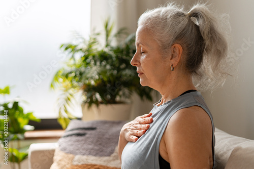 Foto Senior woman practicing mindfulness and deep breathing at home